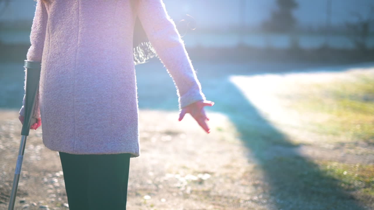 Woman with Crutches Walking Outdoors