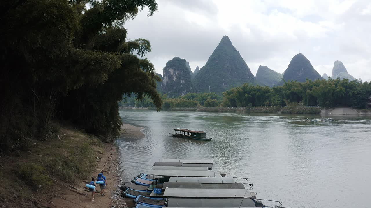 antena: excursionistas caminando paisaje de montaña kárstica del río li, china, vista de seguimiento