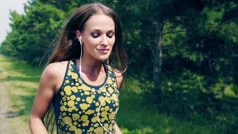 CU-Portrait-Young-girl-goes-in-for-sports-in-the-morning-runs-along-a-pine-forest-4-she-has-wristlets