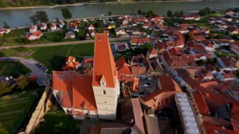 fpv volando sobre viñedos hacia el monasterio de la abadía de diseño de cabañas en la ciudad de weissenkirchen, austria