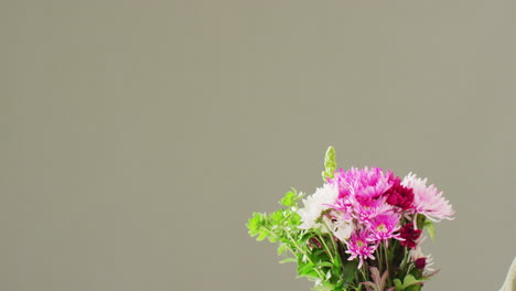 video de una mujer sosteniendo un ramo de flores con espacio de copia en un fondo gris