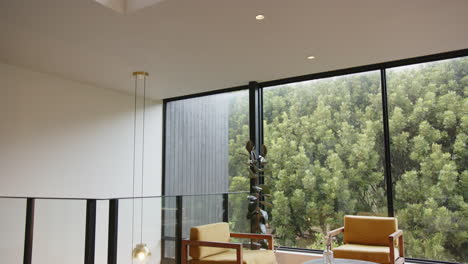 modern living room with large windows, two armchairs, and round table, copy space