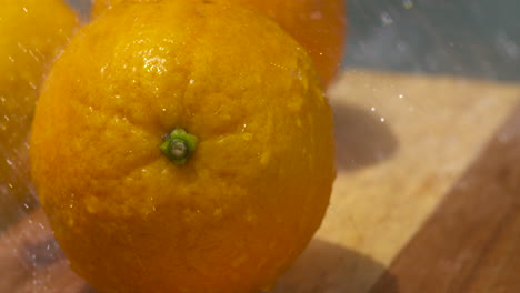 Washing-fresh,-ripe-navel-oranges-in-the-sunlight