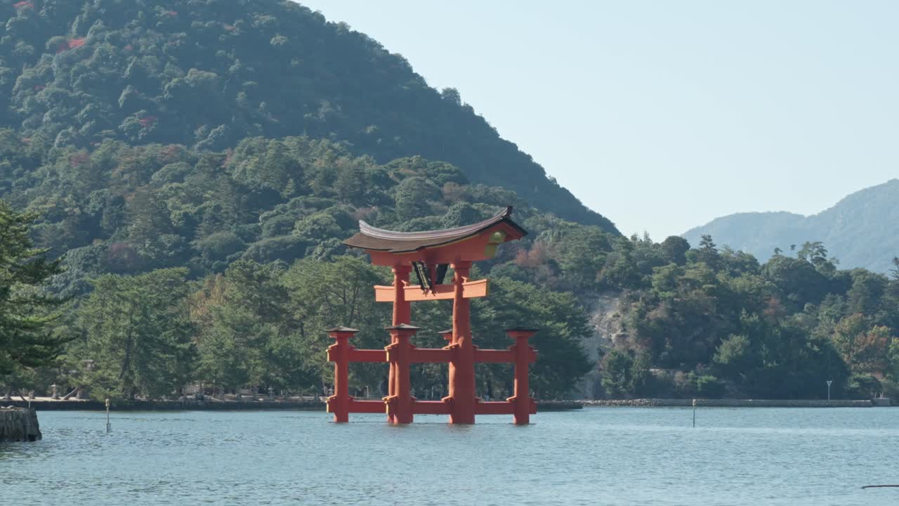 A serene capture of the Itsukushima Jinja torii gate on Miyajima Island, perfectly positioned in Hiroshima's waters, blending spiritual heritage with natural tranquility.