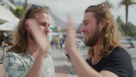 portrait of handsome twin brothers high five celebrating successful summer travel vacation smiling enjoying sunny beachfront together