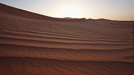 puesta de sol sobre vastas dunas del desierto con hermosos patrones de arena