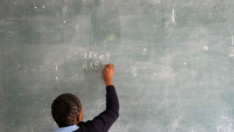 schoolgirl writing on chalkboard in classroom 4k