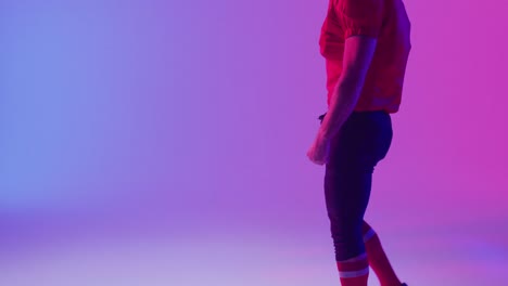 Video-Eines-Kaukasischen-American-Football-Spielers-Mit-Helm-Und-Kopierraum-Auf-Neonviolettem-Hintergrund