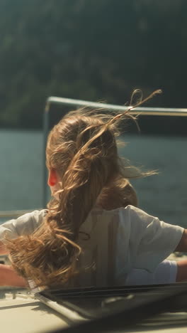 calm girl and boy straighten arms to sides sailing on motorboat on sea on sunny day. siblings relax enjoying stunning view in summer. observing beauty of nature