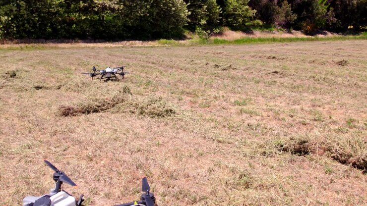 Dois drones profissionais de alta tecnologia, especializados em fertilização agrícola, pousados no chão em um campo de cultivo
