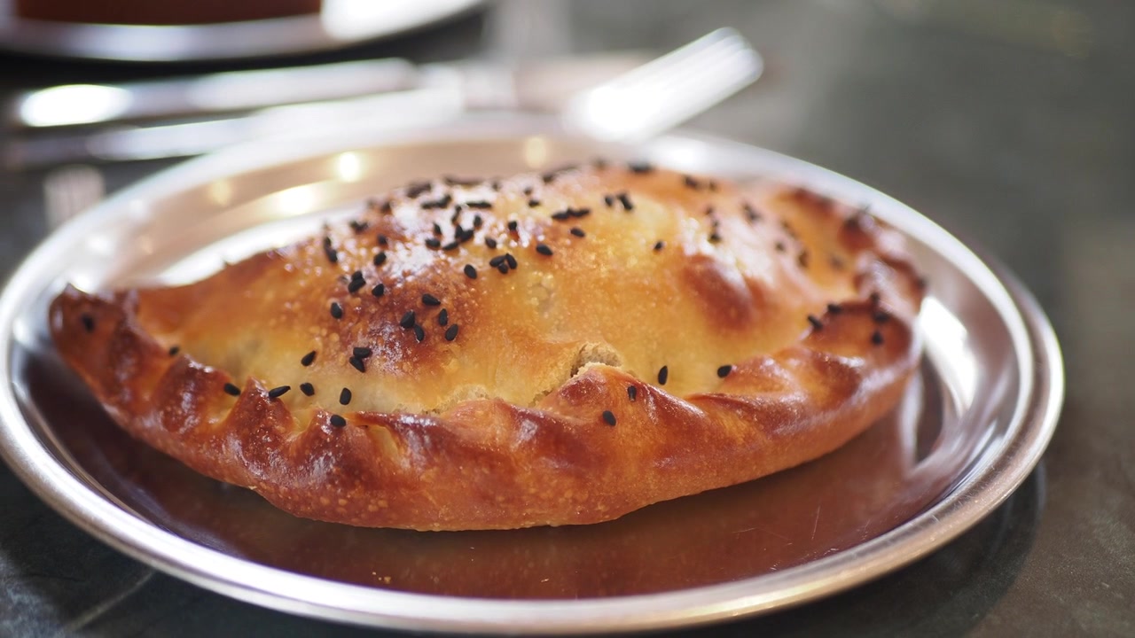 Freshly Baked Calzone Pastry on a Metal Plate