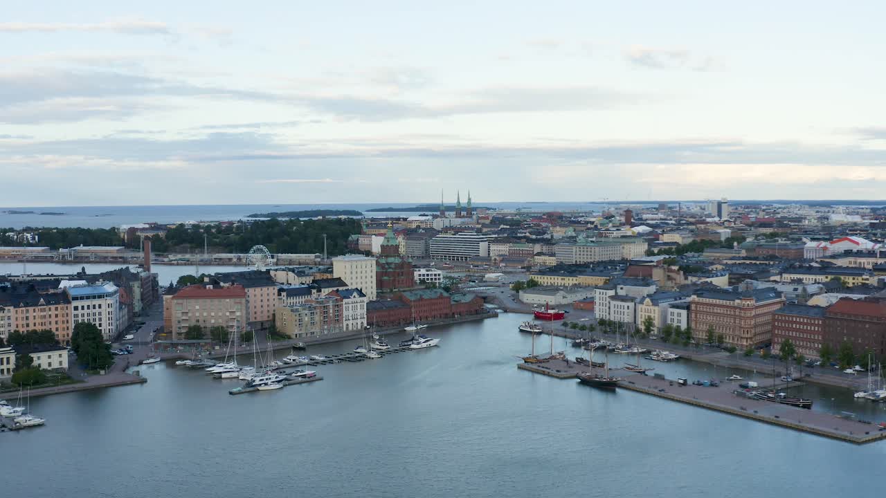 lenta panorámica aérea de barcos a lo largo de la costa con una noria a la vista al atardecer, finlandia