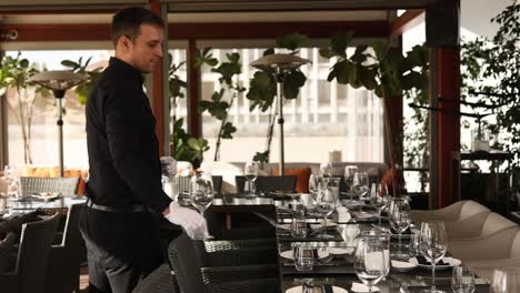 waiter setting tables in outdoor restaurant