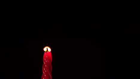 luz de vela roja sobre fondo negro