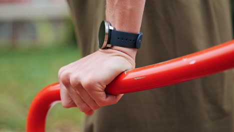 hombre entrena en un parque público sesión de entrenamiento de monitoreo con reloj inteligente, primer plano