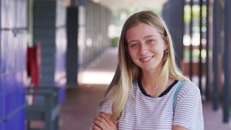 white teenage girl walks into focus in high school corridor