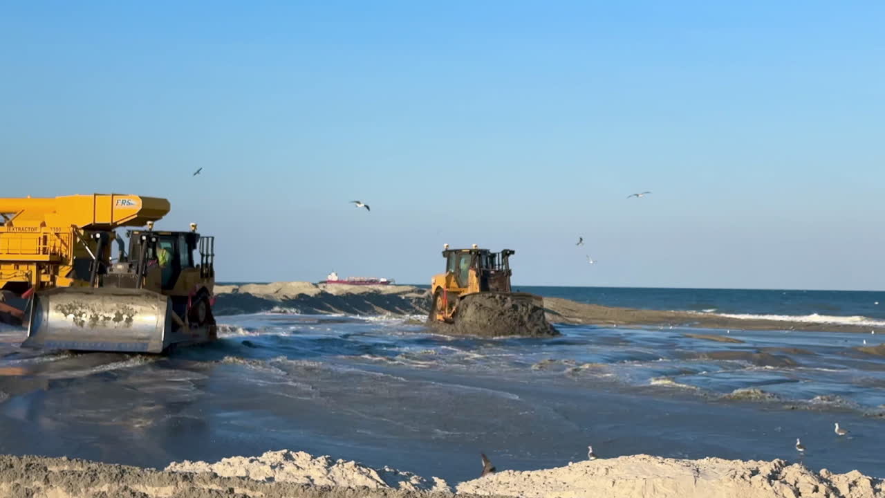 Bulldozers sandscaping during shoreline beach sand replenishment