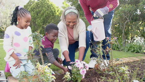 Happy-african-american-grandparents,-grandson-and-granddaughter-gardening-together,-slow-motion