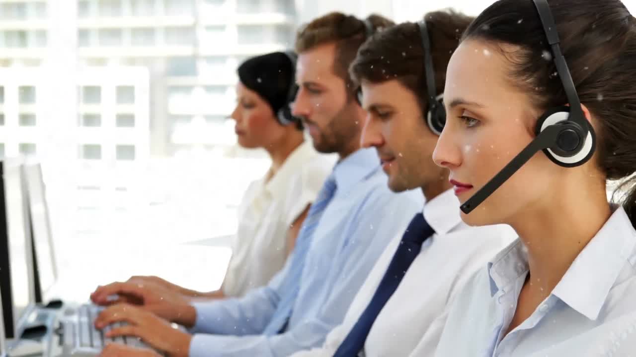 animación de nevadas sobre diversos representantes de servicio al cliente que trabajan en la computadora en la oficina.