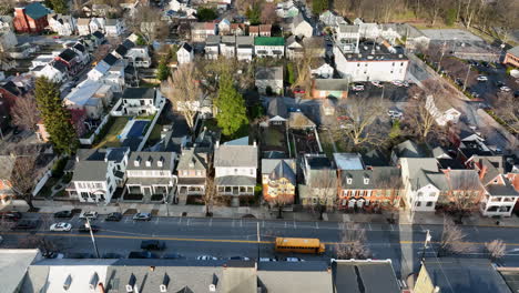 Yellow-school-bus-on-street-through-small-town-America-homes