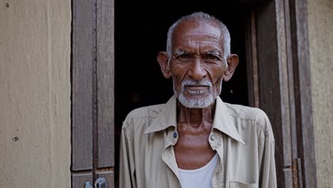 weathered elderly man standing in wooden doorway, embodying wisdom and dignity of rural life, reflecting deep generational experience and cultural heritage