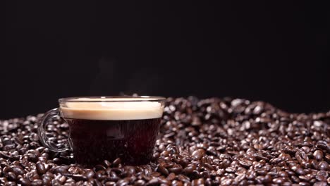 coffee cup with steam in coffee beans with black background in 4k