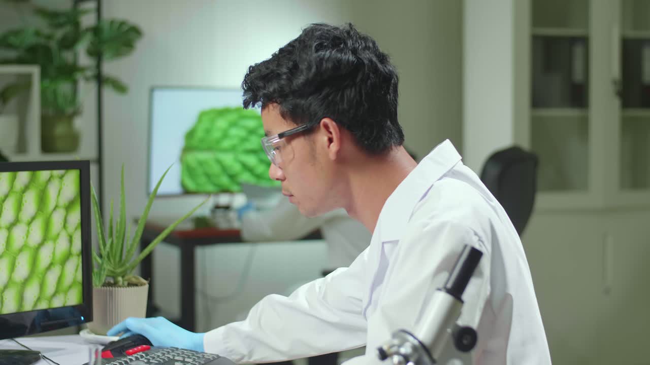 Scientist Asian Man Researcher Biochemistry Expertise On Computer For Microbiology Experiment