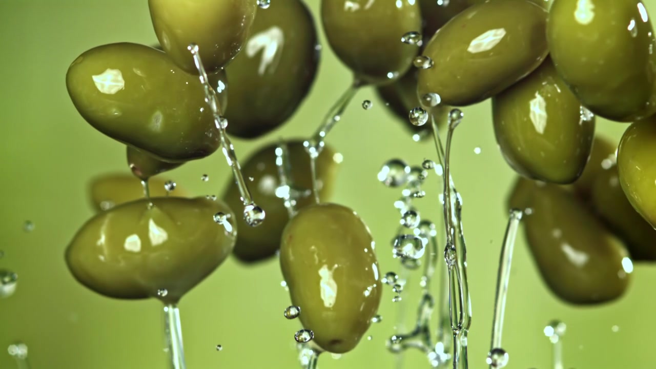 Olive verdi fresche che schizzano in acqua al rallentatore