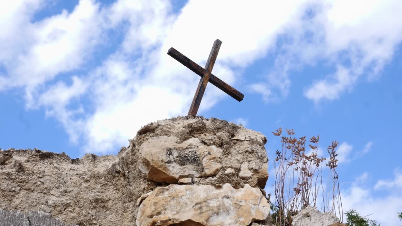 Iron cross on a stone pedestal on the wall of the abandoned cemetery of Jaén