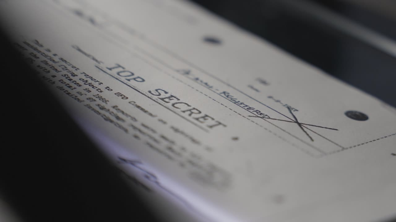Top secret report or document passing through scanner or copy machine in dark room. Close up on censored classified confidential government paper with intelligence sensitive information leaked exposed