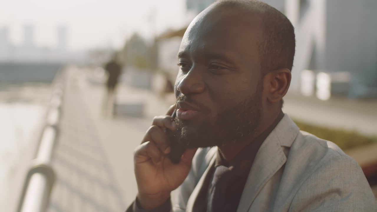 African American Businessman Holding Coffee and Talking on Phone Outdoors
