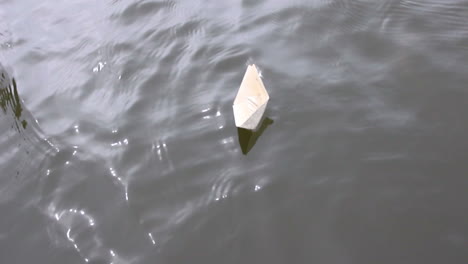active leisure for children. boy play in paper ship in water puddel