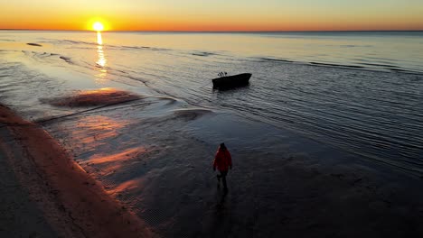 Una-Persona-Camina-Por-La-Playa-Arenosa-E-Inusual-Al-Atardecer,-Donde-El-Terreno-Es-Inusual