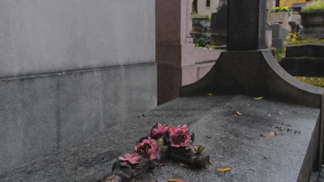 beautiful crucifix on top of a grave a rainy day in pere lachaise cemetary