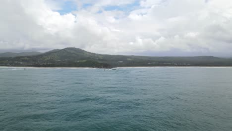 Schöne-Seelandschaft-Mit-Blauem-Bewölktem-Himmel-Und-Bergen-Im-Hintergrund-In-Sapphire-Beach,-Coffs-Harbour,-Nsw,-Australien---Luftdrohnenaufnahme