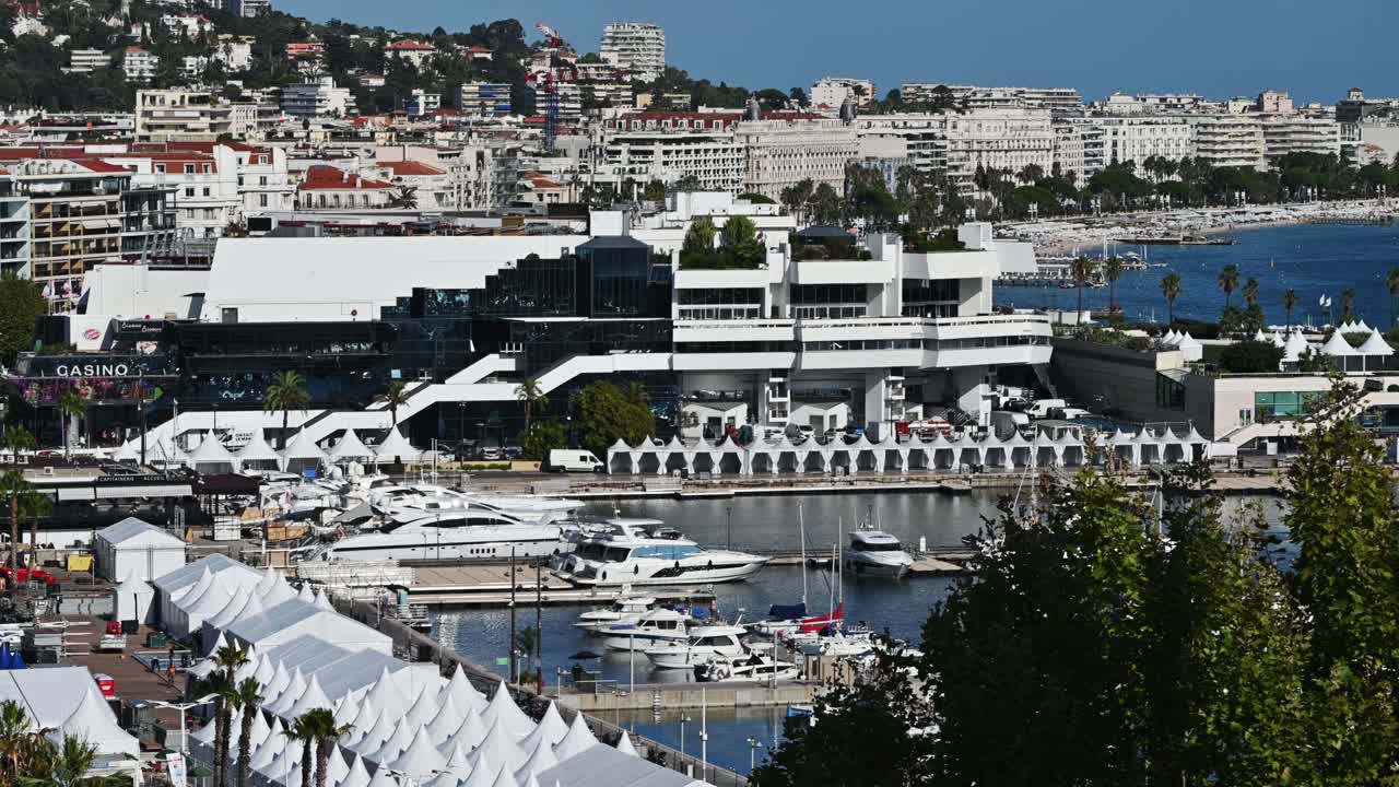 View of the sea port of Cannes, France. Moored yachts, buildings, greenery, Mediterranean sea