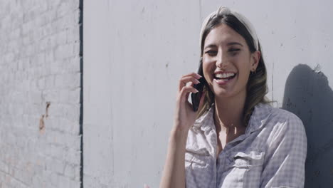 young woman laughing while talking on the phone