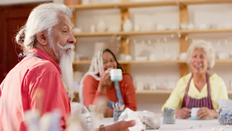 Happy-diverse-group-of-potters-having-break-and-discussing-in-pottery-studio,-slow-motion