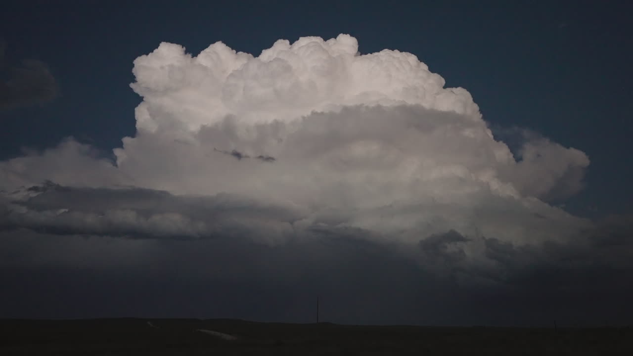 Dramatic Cloud Formation Over a Dark Landscape