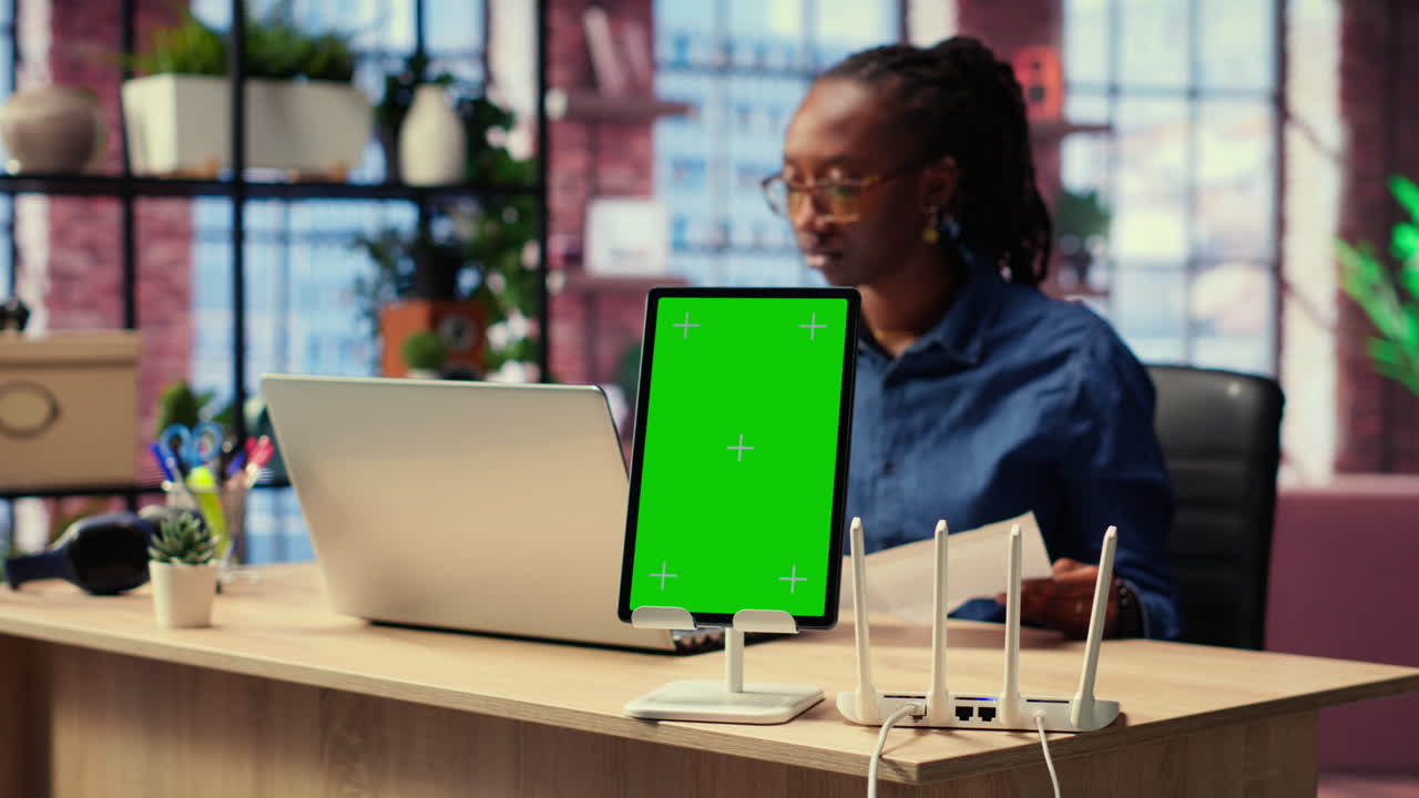 la chica negra trata de arreglar el error del wi-fi reiniciando el enrutador junto a la pantalla aislada