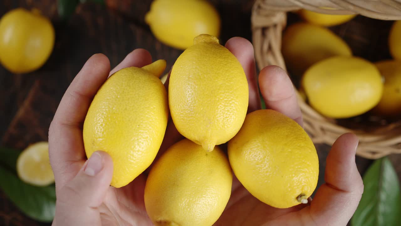 Men's hands holding fresh lemons.