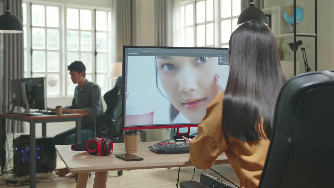 Back View Of Asian Female Digital Editor Works In Photo Editing Software On Her Personal Computer With Big Display In Office