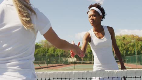 Video-of-african-american-female-tennis-player-holding-racket-and-shaking-hand-with-friend