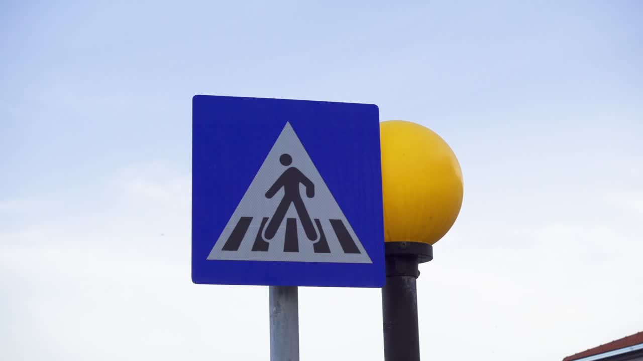 señal de cruce de peatones no regulada contra el cielo azul del atardecer. semáforo redondo amarillo parpadeando