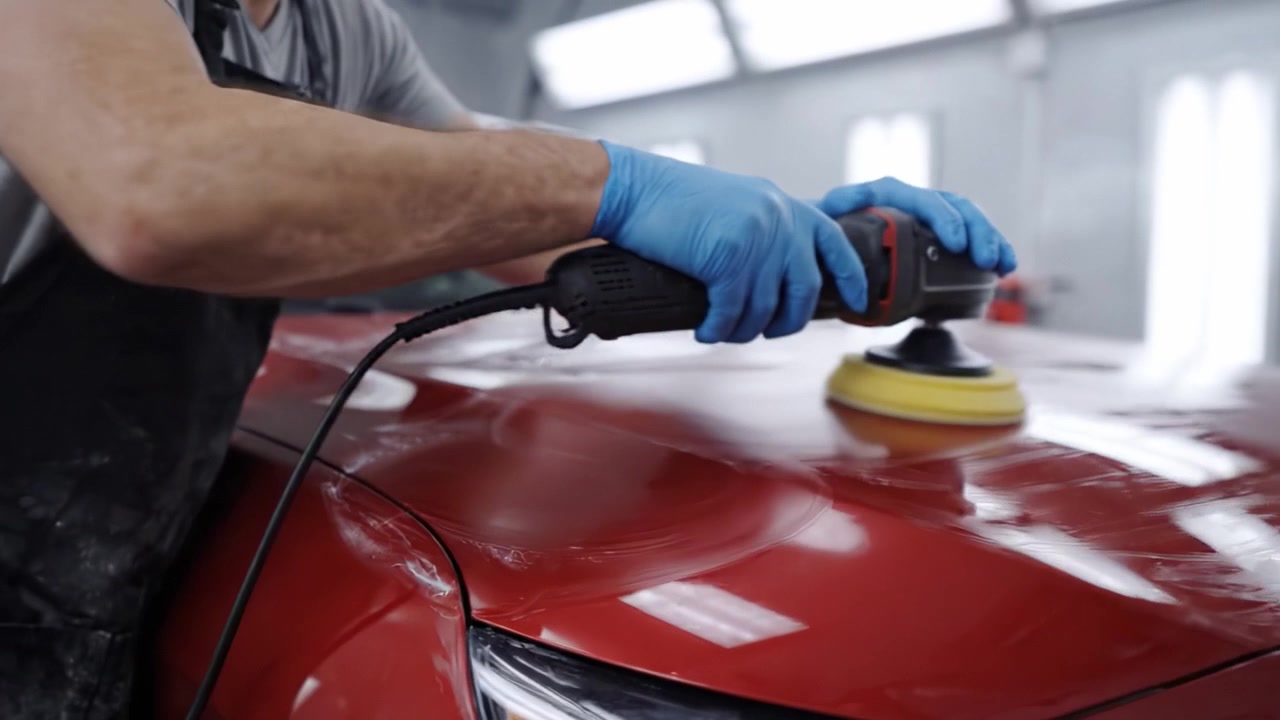 Professional Car Detailing Process: Polishing a Brilliant Red Vehicle to Restore Shine and Enhance Appearance in an Auto Detailing Studio