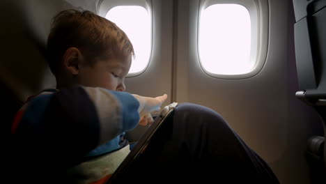 Niño-Jugando-En-El-Panel-Táctil-En-El-Avión