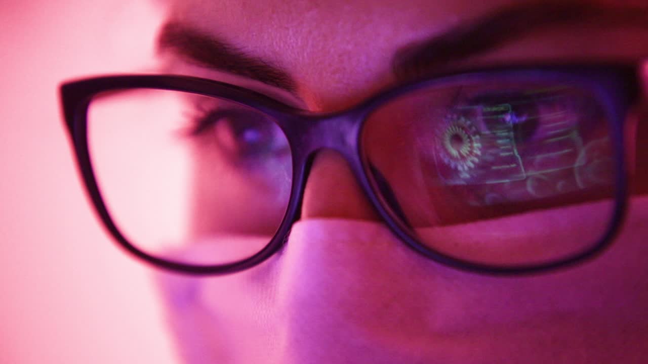 Scientist woman studying data of Coronavirus outbreak virus model displayed on laptop screen reflected on glasses