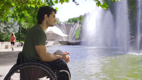 thoughtful disabled teenager. thoughtful young man sitting in a wheelchair.