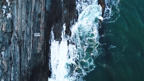 Un-Hombre-Mirando-Las-Olas-Golpear-Las-Rocas-Abajo-En-Curtis-Island-Lighthouse-Camden-Maine,-EE.UU.