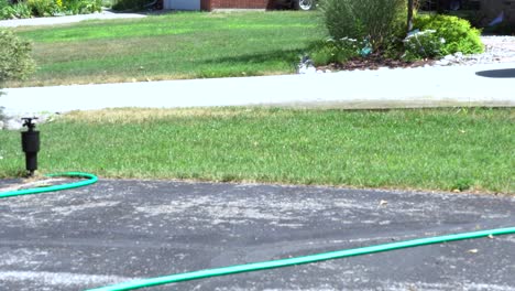 A-man-walks-into-frame-to-adjust-a-sprinkler-and-its-path